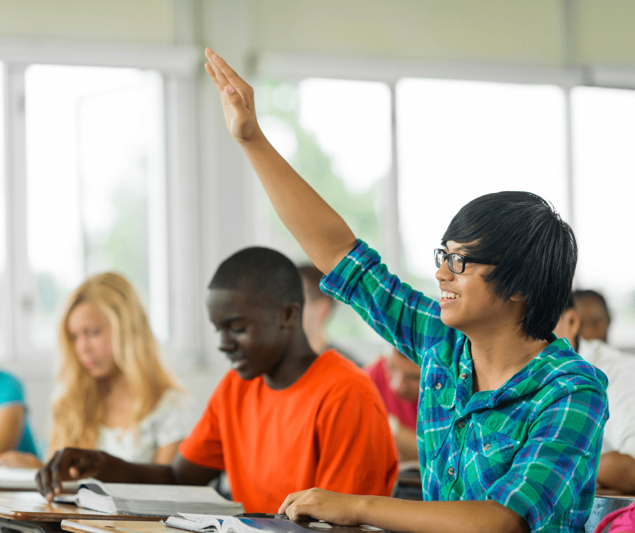 Student smiling and raising his hand